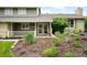Inviting covered front porch with double doors, framed by lush landscaping with vibrant purple flowers at 5586 Colorow Dr, Morrison, CO 80465