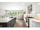 Bright eat-in kitchen featuring a large island, modern appliances, white cabinets, and outdoor access at 5586 Colorow Dr, Morrison, CO 80465