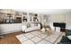 Cozy living room with hardwood floors, large rug, and access to the outdoor patio at 5586 Colorow Dr, Morrison, CO 80465