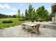 An inviting outdoor patio with dining table, chairs and steps to a seating area overlooking the expansive yard at 5586 Colorow Dr, Morrison, CO 80465