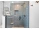 Stylish walk-in shower featuring blue subway tile, glass door, and sleek fixtures at 5586 Colorow Dr, Morrison, CO 80465