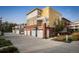 Exterior shot showcasing attached garages of townhomes with a yellow and olive color scheme at 1231 Cedar Ave, Boulder, CO 80304