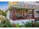 Relax on this charming front porch, featuring comfortable seating and colorful pillows overlooking beautiful landscaping at 1231 Cedar Ave, Boulder, CO 80304