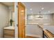 Hallway leading to powder room with a wood door, modern fixtures, and warm lighting at 1231 Cedar Ave, Boulder, CO 80304