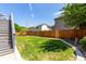 Spacious backyard featuring well-maintained lawn, wood fence, and stairs leading up to the back of the house at 6694 E 129Th Ave, Thornton, CO 80602
