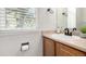 Bright half bath with light wood vanity and natural light streaming through window blinds at 6694 E 129Th Ave, Thornton, CO 80602