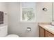 Cozy half bath featuring a light wood vanity and a view to the outside through window blinds at 6694 E 129Th Ave, Thornton, CO 80602