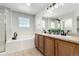 Bathroom featuring double sinks, a soaking tub, and a shower with a glass enclosure at 6694 E 129Th Ave, Thornton, CO 80602