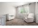 Bedroom room featuring a chair, changing table, and view of a baby's crib at 6694 E 129Th Ave, Thornton, CO 80602