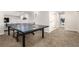 Open concept rec room featuring a ping pong table, sitting area, and doorways to an office space at 6694 E 129Th Ave, Thornton, CO 80602