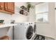 Bright laundry room featuring a modern washer and dryer, with plenty of counter space and storage shelving at 6694 E 129Th Ave, Thornton, CO 80602