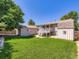 Lush backyard with well-maintained lawn, convenient storage shed, and stairs to a deck at 1576 S Ursula Ct, Aurora, CO 80012