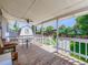 Cozy covered deck with wooden flooring, ceiling fan, seating and white railing at 1576 S Ursula Ct, Aurora, CO 80012