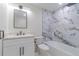 Beautiful bathroom featuring marble tile, modern fixtures, and a soaking tub with shower at 6735 W 2Nd Ave, Lakewood, CO 80226