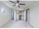 Bedroom features a ceiling fan, carpet, and sliding closet doors with built-in shelving at 6735 W 2Nd Ave, Lakewood, CO 80226