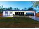 Modern home with a manicured lawn, sleek black accents, a dark roof, and an attached garage at 6735 W 2Nd Ave, Lakewood, CO 80226