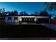 Night view of a modern home with a well-manicured lawn, sleek black accents, and an attached garage at 6735 W 2Nd Ave, Lakewood, CO 80226