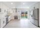 Bright kitchen features white cabinets, stainless steel appliances, and sliding glass door to the backyard at 6735 W 2Nd Ave, Lakewood, CO 80226