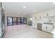 Modern kitchen featuring white cabinets, stainless steel appliances, and an open view to the living area at 6735 W 2Nd Ave, Lakewood, CO 80226