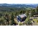 Scenic aerial view showcases home among mature trees and breathtaking mountain landscape at 22598 Westview Ave, Golden, CO 80401