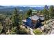 Exterior view of a wooden home nestled among lush trees and greenery at 22598 Westview Ave, Golden, CO 80401