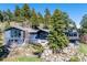 Stunning exterior of the wood-clad home surrounded by lush trees and greenery at 22598 Westview Ave, Golden, CO 80401
