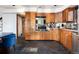 Kitchen with wood cabinets, stone floors, stainless steel appliances, and black and gray backsplash at 22598 Westview Ave, Golden, CO 80401