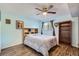 Bedroom with ceiling fan, wood flooring, and a large bookshelf at 3141 S Tamarac Dr # 110G, Denver, CO 80231