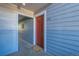 A red front door with the unit number and welcome mat is set against blue siding at 3141 S Tamarac Dr # 110G, Denver, CO 80231