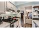 Kitchen with stainless steel stove and white cabinets open to living area at 3141 S Tamarac Dr # 110G, Denver, CO 80231