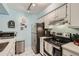 Functional kitchen with stainless steel appliances, white cabinets, and tile flooring at 3141 S Tamarac Dr # 110G, Denver, CO 80231