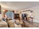 Cozy living room features a brick fireplace, wood floors, and access to an outdoor patio at 3141 S Tamarac Dr # 110G, Denver, CO 80231