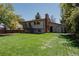 Expansive backyard with a lush lawn, wooden deck, and mature trees at 8559 W 75Th Pl, Arvada, CO 80005