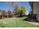 Spacious backyard with lush green grass, privacy fence, and mature trees at 8559 W 75Th Pl, Arvada, CO 80005