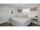Cozy bedroom with striped bedding, decorative pillows, and a bright window at 8559 W 75Th Pl, Arvada, CO 80005