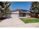 Charming single-story home with a well-manicured lawn and solar panels on the roof at 8559 W 75Th Pl, Arvada, CO 80005