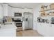 Bright kitchen featuring stainless steel appliances, white cabinetry, and ample counter space at 8559 W 75Th Pl, Arvada, CO 80005