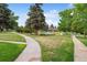 A scenic view of a lush community green space with walking paths, mature trees, and a tranquil pond at 46 Douglas Dr, Broomfield, CO 80020