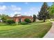 Exterior view of a well-maintained home with a lush green lawn and mature trees on a sunny day at 46 Douglas Dr, Broomfield, CO 80020