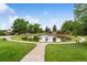 Scenic community pond featuring a fountain, lush greenery, and walking path at 46 Douglas Dr, Broomfield, CO 80020