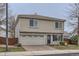 Two-story home with a brick driveway, gray stucco, tile roof, and attached two car garage at 20000 E Mitchell Pl # 39, Denver, CO 80249