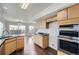 Kitchen with stainless steel oven, black countertops, cabinets, and wood floors at 20000 E Mitchell Pl # 39, Denver, CO 80249