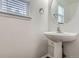 Stylish powder room features a modern pedestal sink and bright natural light at 20000 E Mitchell Pl # 39, Denver, CO 80249