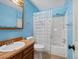 Bright bathroom with blue walls, wooden vanity, and shower with curtain at 1935 W 102Nd Ave, Thornton, CO 80260