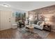 Bright living room with wood-paneled accent wall, stylish decor, and ample natural light at 1935 W 102Nd Ave, Thornton, CO 80260
