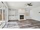 Bright living room features a cozy fireplace, custom shelving, and hardwood floors at 17040 Numa Pl, Parker, CO 80134