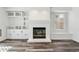 Living room with a white painted fireplace, built-in cabinets, and hardwood floors at 17040 Numa Pl, Parker, CO 80134