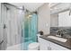 Modern bathroom featuring tiled shower with sliding glass door, sleek vanity, and stylish mosaic tile accents at 2508 Kensing Ct, Denver, CO 80211