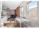 Open-concept dining room and living space with hardwood floors and exposed brick that is connected to the modern kitchen at 2508 Kensing Ct, Denver, CO 80211