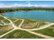 Aerial view of Waneka Lake, showcasing the walking trails, lush greenery, and the stunning mountain backdrop at 2552 Stonewall Ln, Lafayette, CO 80026